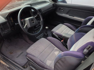 Stock shifter, stock steering wheel (with cover), stock floor mats (with stains).